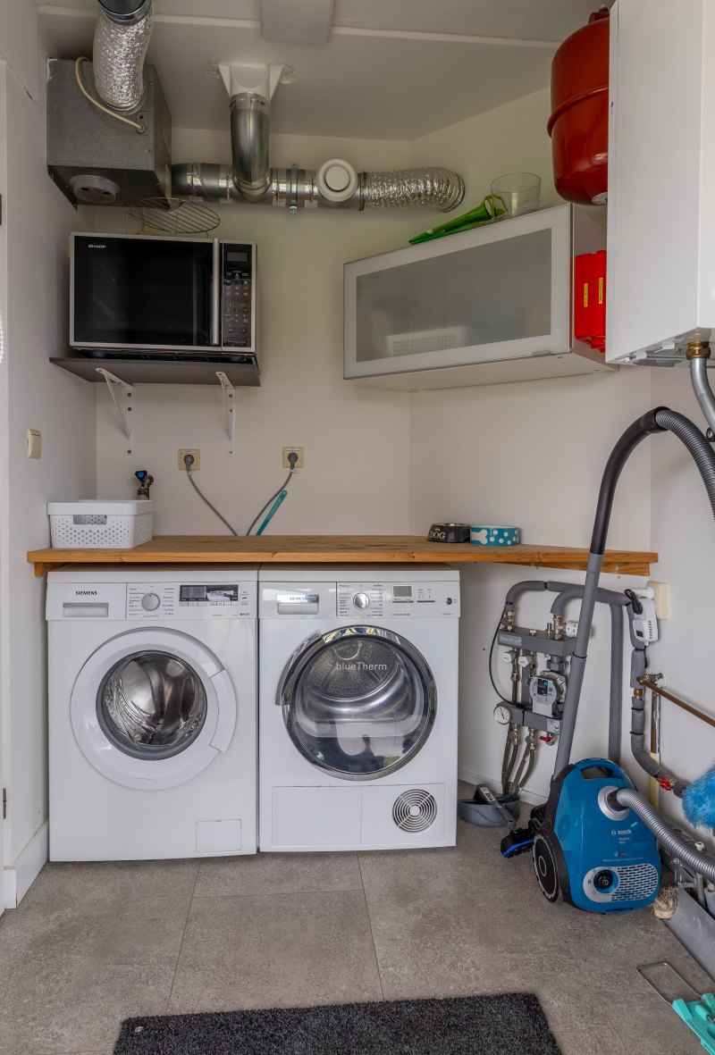 De bijkeuken met wasmachine en droger